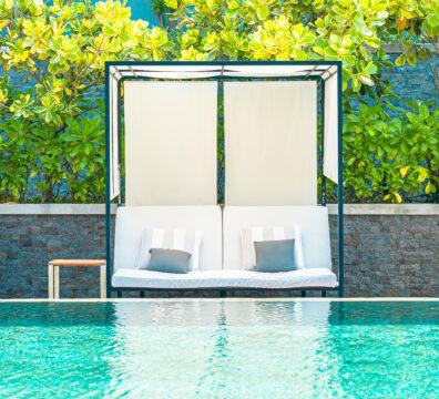 Umbrella and chair around outdoor swimming pool in hotel resort